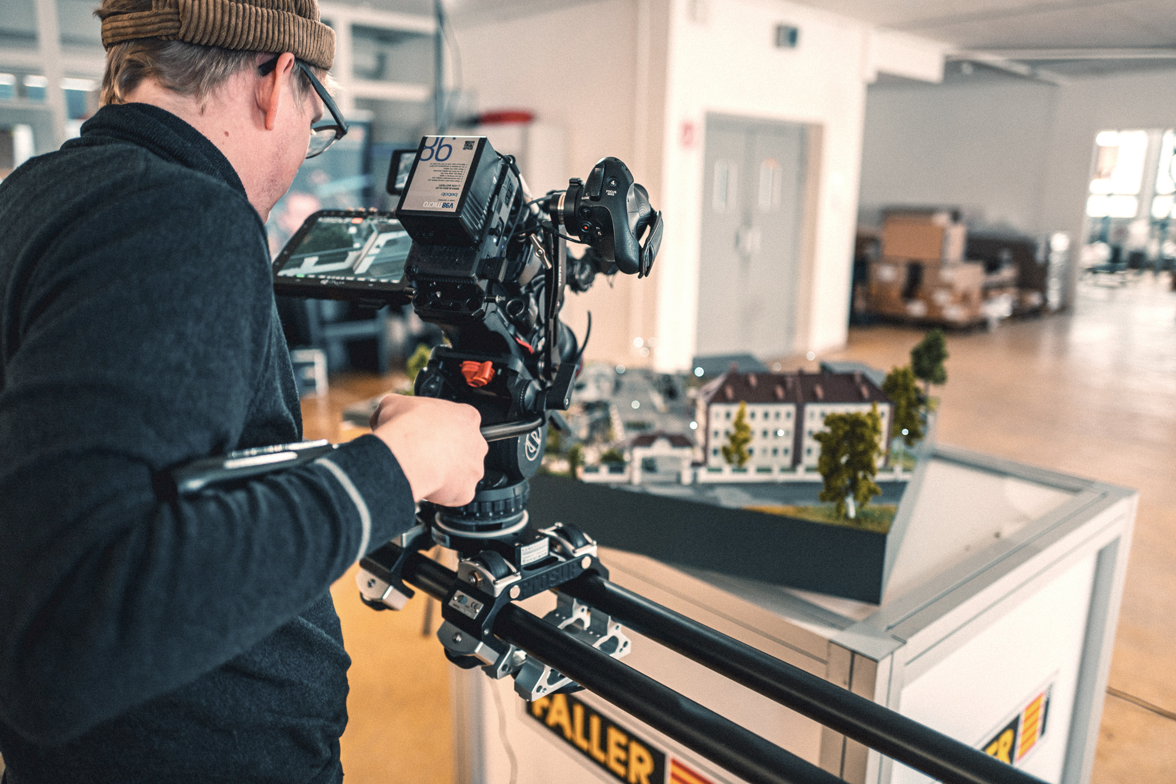 mediatenne-produktionsmanagement Zu sehen ist ein Kameramann, der eine Kamera in der Hand hat und etwas filmt.